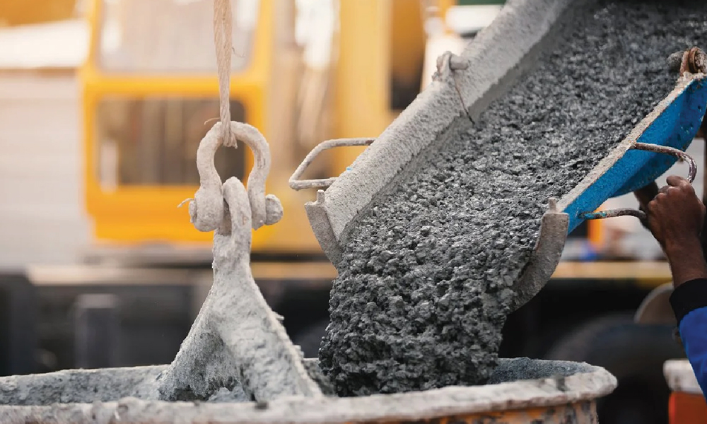 A transit mixer pouring concrete at a construction site.